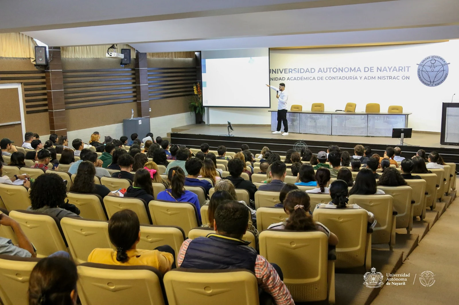 Personas asistentes en un auditorio.